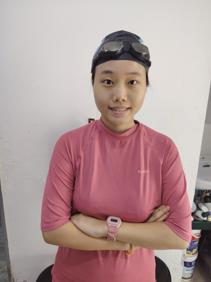 Coach Yiqi, kids and adult coach, poolside in her swim cap and goggles